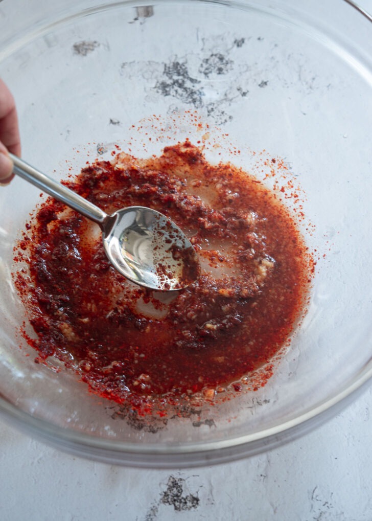 Spicy red chili vinaigrette mixed with a spoon in a bowl