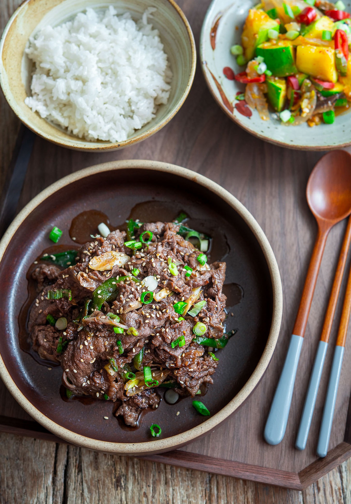 Korean beef bulgogi served with rice and vegetable side dishes on a tray