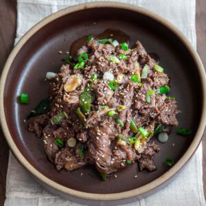 Korean beef bulgogi with glossy caramelized slices and green onion garnish