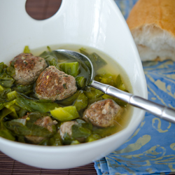 Kale meatball soup is served with a spoon