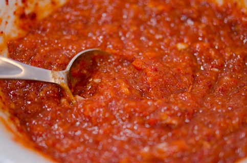 Kimchi paste is made with chili and other seasoning and showing its loose consistency.