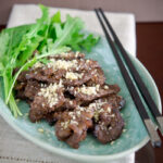 Nuhbiani garnished with pine nuts in a serving dish.