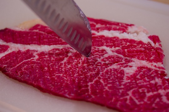 Knife poking the beef meat.