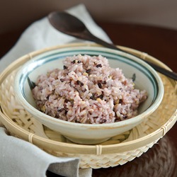 A bowl of multigrain (mixed grain) rice is on a bamboo basket.