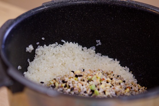 White rice and mixed grains are combined in a bowl of electric rice cooker.