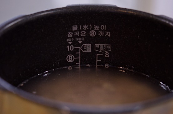 Water is added to the multigrain rice in an electric rice cooker.