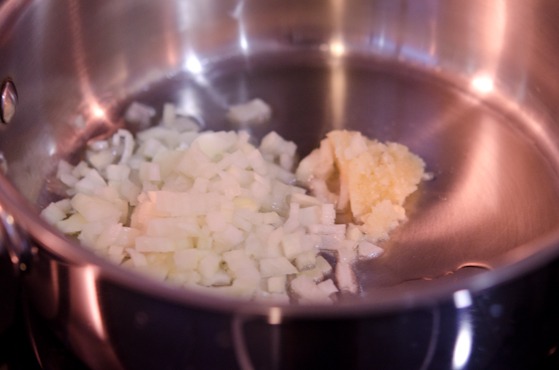 Minced onion and garlic is placed in hot oil in a pan.