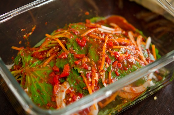 Kkaennip kimchi (perilla kimchi) is packed together in a glass container.