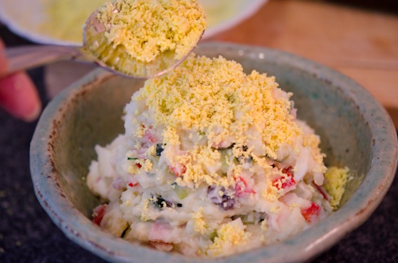 Egg yolk crumbs are topped over Korean potato salad