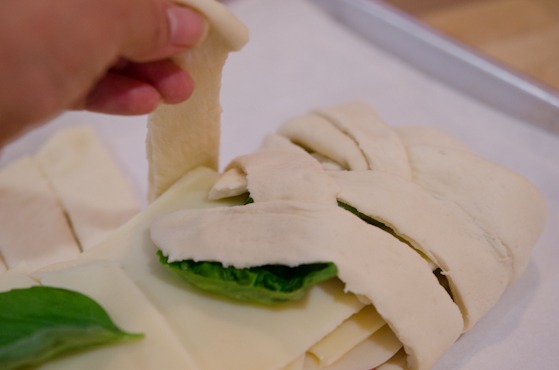Bring the strips on the side to wrap the Stromboli filling in criss-cross braided pattern.