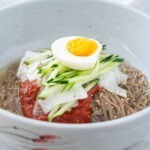 Korean naengmyeon cold noodles with spicy bibim sauce, cucumber, and egg