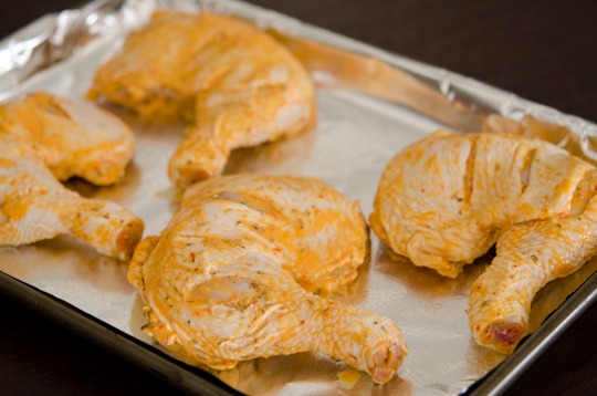 Chicken legs marinated with peri peri sauce is getting ready to bake.