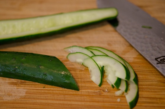 A seeded cucumber is sliced thinly.