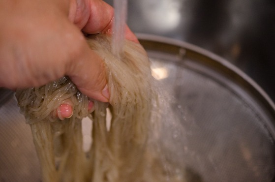 Nangmyeon noodles are being rinsed under the cold running water.