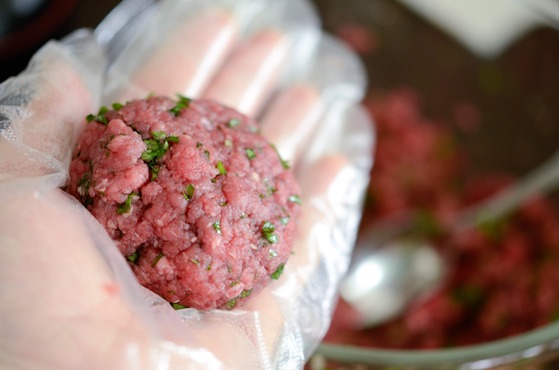 A piece of beef patties are formed in a hand