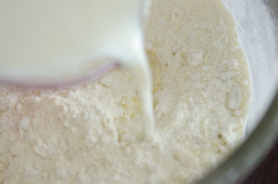 Milk is added to the sweet potato and rice flour mixture to make rice donuts.