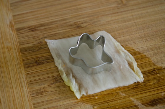 A ghost shaped cookie cutter is used to cut out a piece of kimchi.