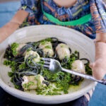 Black spaghetti with pesto sauce in a bowl.