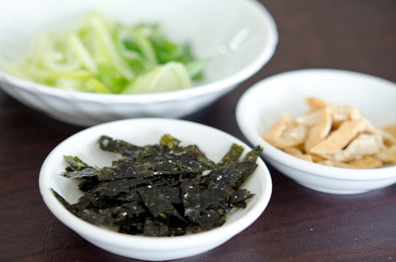 Roasted seaweed and fried bean curd is prepared to garnish udon soup.
