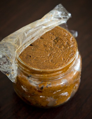 Homemade Korean Soy Bean Paste stored in a glass jar is showing its golden color.