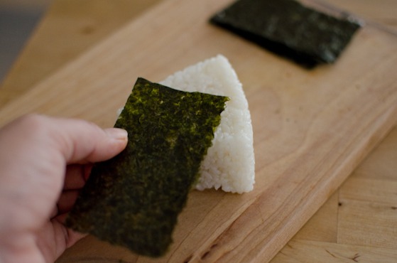 Wrap the rice onigiri with a piece of seaweed on the bottom.