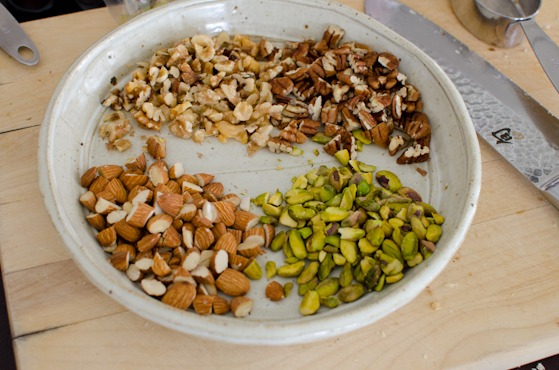 Nuts are coarsely chopped and collected on a round dish.