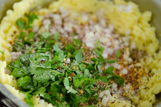 Mashed potatoes are combined with coriander, chili flakes and other spices.