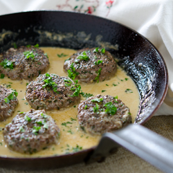 Parsley Peppercorn Beef Pattieswith cream sauce is served with mashed potatoes.