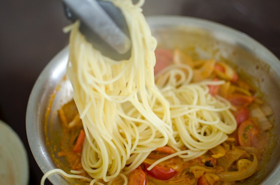 Add the cooked spaghetti noodles into the kimchi tomato sauce in a pan.