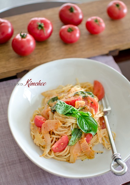 Spaghetti is cooked with kimchi, fresh tomato, and a little bit of cream.