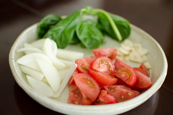Prepare onion, tomato, basil, and sliced garlic in a plate.