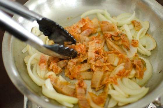 Add kimchi to onion garlic mixture in a pan
