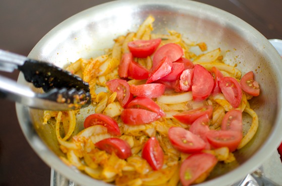 Add tomato slices to the kimchi mixture in a pan.