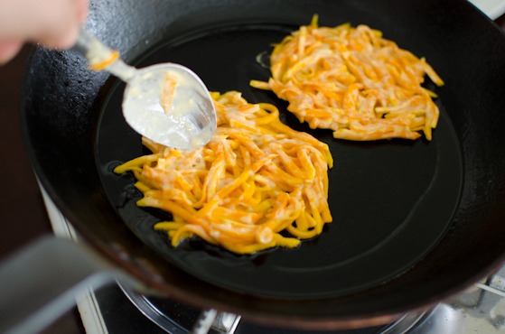 Spread a thin layer of Korean pumpkin pancake batter into hot oil.