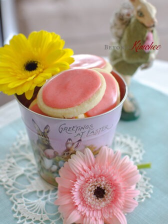 Soft sugar cookies with fresh strawberry icing is decorated with spring flowers.