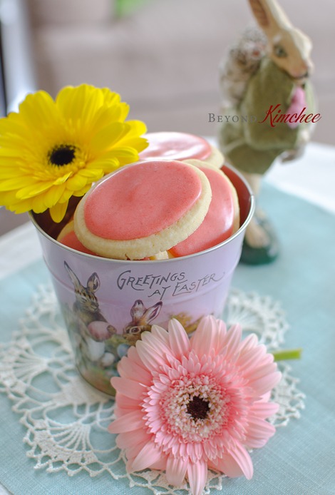 Soft sugar cookies with fresh strawberry icing is decorated with spring flowers.