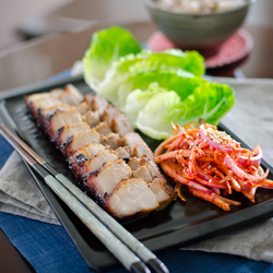 Oven Roasted Korean Pork Belly is served with lettuce and onion salad