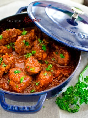 Cape Malay chicken curry is garnished with parsley in a blue pot with a lid