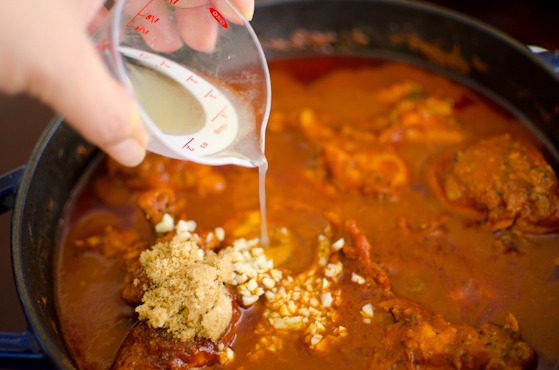 Sugar, garlic, and lemon juice is added to the curry mixture in a pot.
