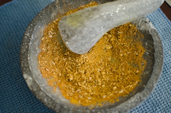 Curry spices are pounded in a mortar with a pestle.