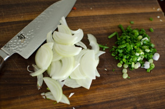 Thin slices of onion and chopped green onion are ready for a Korean salad recipe.