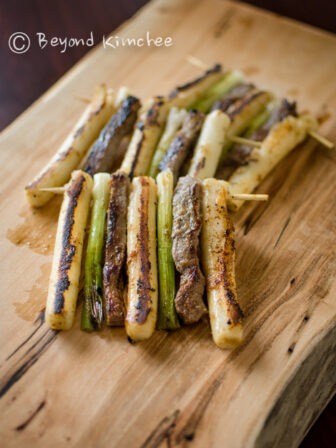 Beef, rice cake, and green onion are skewered together and pan-fried.