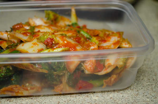 Freshly made kimchi is stored in a container,