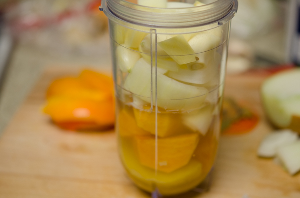 Persimmon, onion, and vegetable stock is combined in a mini processor.