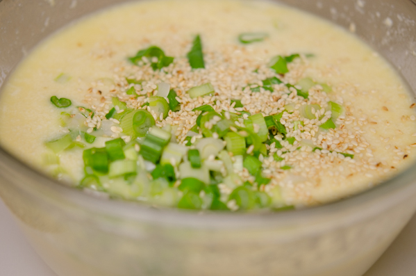 Chopped green onion and sesame seeds are added t tofu egg mixture.