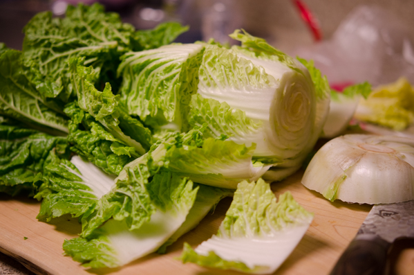 A whole cabbage is sliced to make vegan kimchi.