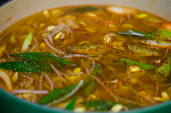 Slices of Asian leeks and black pepper are added to the spicy beef bean sprout soup.