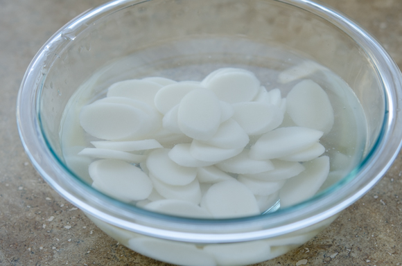 Korean rice cake rounds are soaking in water.