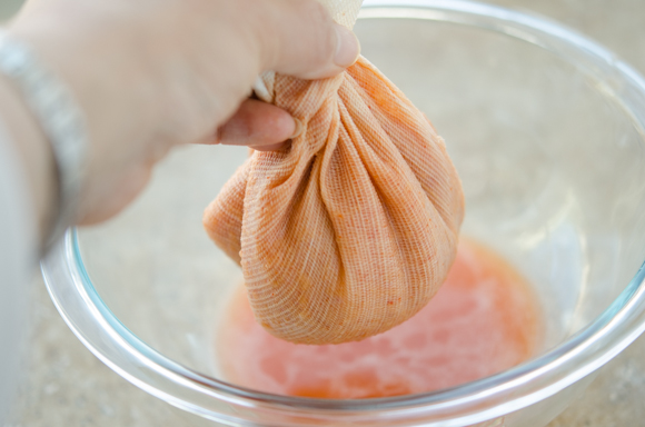 A piece of cloth holding kimchi filling inside is twisted to extract the moisture.