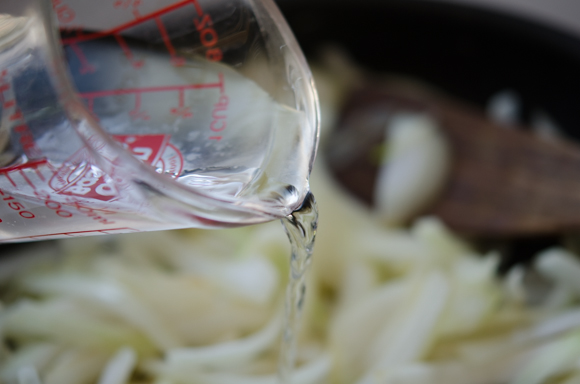 Water is added to the onions in a skillet.